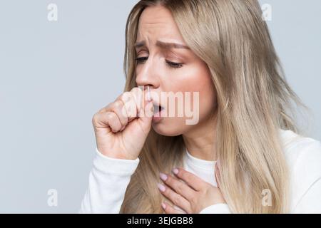 Ungesunde Frau mit Husten, isoliert. Kranke Frau hat Grippe. Bronchitis. Halsschmerzen Stockfoto