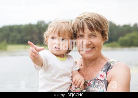 Glückliche Großmutter mit ihrem Enkelkind im Sommer draußen. Stockfoto