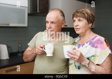 Glückliches Seniorenpaar trinkt Tee in der Küche Stockfoto