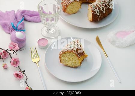 Oster-Tisch mit Blick aus einem hohen Winkel, glasierter Osterkuchen und Kerzen auf dem Tisch, der für Ostern dekoriert ist Stockfoto