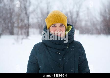 Porträt einer lächelnden Seniorin. Großmutter im Schnee draußen. Stockfoto