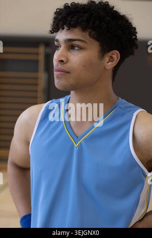 Männlicher Athlet, der im Fitnessstudio auf dem Gerichtsboden neben hölzernen Wandstangen steht, trägt blaues Jersey und Armband. Sport, Fitness, Training, St. Stockfoto