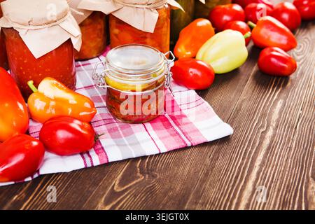 Konserviertes und frisches Gemüse auf dem Heimtisch. Verschiedene hausgemachte Konserven in Glasgläsern Stockfoto