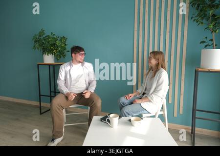 Geschäftsleute, die sich zu Hause unterhalten, häusliche Beratung. Anwalt oder Psychologe, der in freundlicher Umgebung spricht Stockfoto