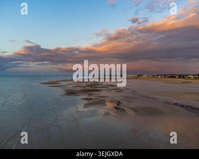 Spektakuläre Aussicht aus der Luft auf Courseulles-sur-Mer mit Ebbe, die Sandbänke und reflektierende Pools freigibt. Im Hintergrund, die Küstenstadt und eine Schönheit Stockfoto