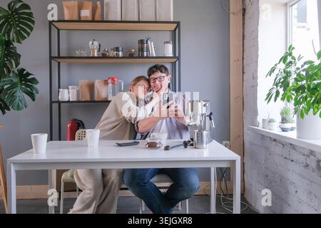 Junge Paare probieren Kaffee zu Hause, machen Kaffee am Morgen Stockfoto