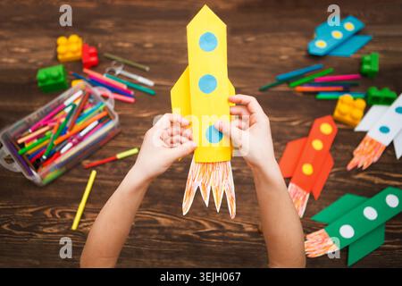 Vorschulkind in Kreativität im Haushalt. Happy Kid macht Raketen aus Papier. Kreativität für Kinder. Kreative Kinder spielen mit Stockfoto