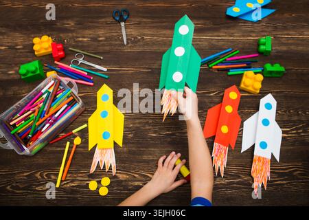 Vorschulkind in Kreativität im Haushalt. Happy Kid macht Raketen aus Papier. Kreativität für Kinder. Kreative Kinder spielen mit Stockfoto