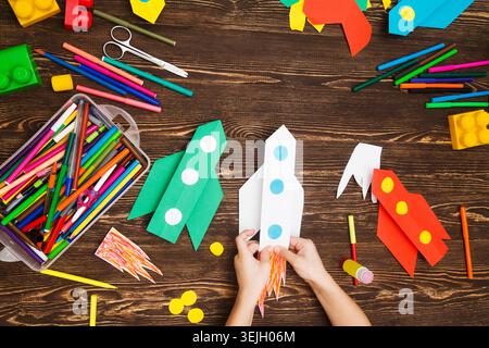 Vorschulkind in Kreativität im Haushalt. Happy Kid macht Raketen aus Papier. Kreativität für Kinder. Kreative Kinder spielen mit Stockfoto