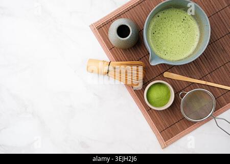 Traditionelles Matcha-Set, Bambusquirl und Getränk auf Bambusmatte in der Küche Stockfoto