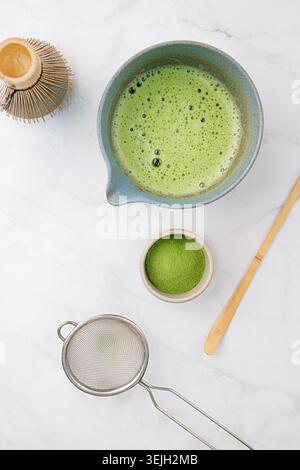 Traditionelles Matcha-Set, Bambusquirl und Getränk auf Bambusmatte in der Küche Stockfoto