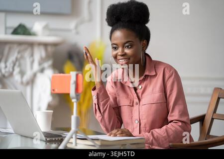 Afro-amerikanische Millennial-Frau mit Afro-Frisur Fernlernen, online auf Laptop arbeiten, mit Freunden über Video CA chatten Stockfoto