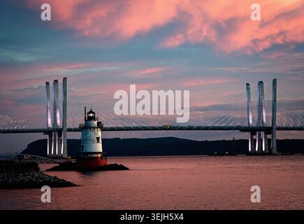 Aus der Vogelperspektive auf Sleepy Hollow Lighthouse und die Governor Mario M. Cuomo Bridge unter einem lebendigen Sonnenuntergang mit rosa Wolken über dem Hudson River Sleep Stockfoto