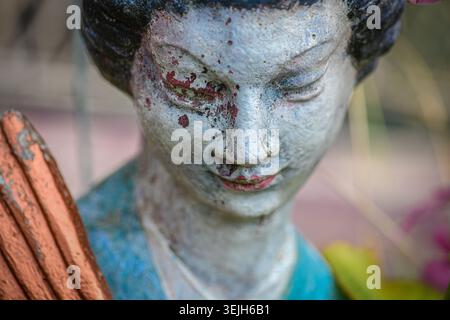 Verwitterte Statue aus nächster Nähe mit abblätternder Farbe und Vintage-Textur Stockfoto