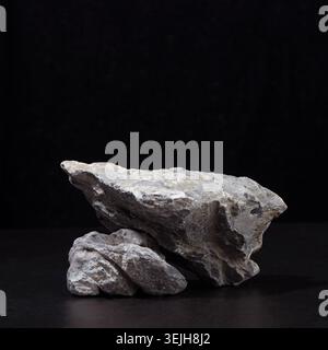 Stein Podium für Verpackung und kosmetische Präsentation auf schwarzem Hintergrund, quadratisch. Stockfoto
