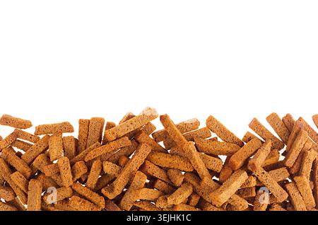 Knusprige Roggencroutons häufen sich als dekorative Grenze mit Kopierraum, isoliert auf weißem Hintergrund. Stockfoto