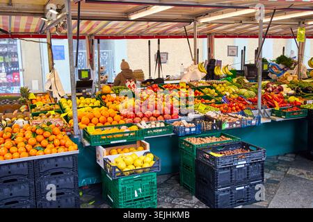 Ein lebhafter Marktstand im Freien mit einer großen Auswahl an frischem Obst und Gemüse. Stockfoto