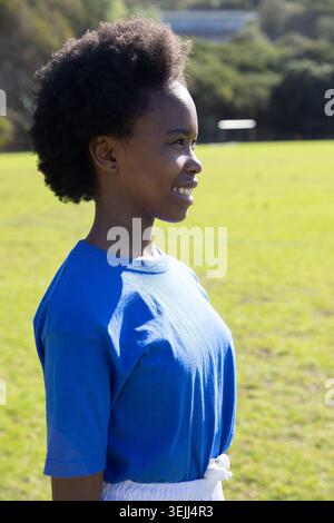 Afroamerikanisches Teenager-Mädchen mit sportlichem Outfit posiert auf dem Fußballfeld mit einem Kopierraum für die Torpost. Athletik, Fitness, Jugend, Outdoor, Energie, vi Stockfoto