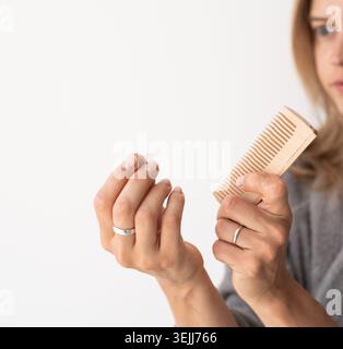 Frau, die ihr Haar putzt, leidet unter Haarausfall Stockfoto