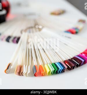 Bunte Kunststoff-Nagelspitzen auf dem Tisch im Manikürsalon Stockfoto