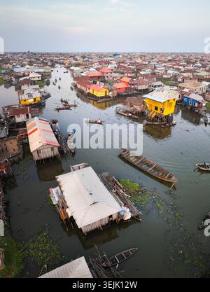 Blick aus der Vogelperspektive auf die farbenfrohen Pfahlhäuser und traditionellen Holzboote im schwimmenden Dorf Ganvie, Atlantique, Benin. Stockfoto