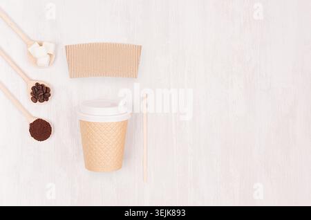 Dekorativer Hintergrund für Restaurant und Café - leerer Papierbecher, Etikett, Kaffeebohnen, Zucker in Löffeln, Kopierraum auf weiß Stockfoto