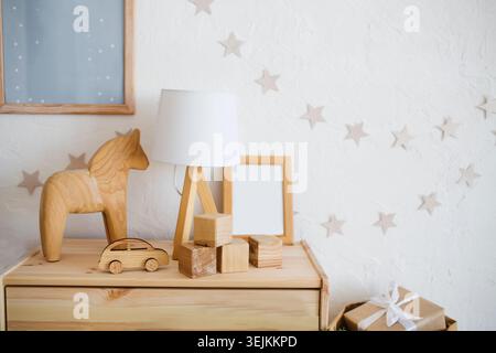 Stilvolles skandinavisches Baby-Zimmer mit Holzspielzeug und Lampe. Keine Verschwendung. Umweltfreundliche Materialien Stockfoto