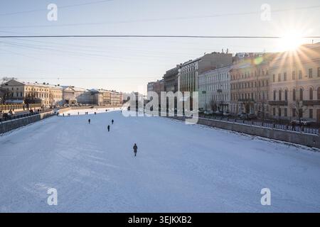 Menschen, die an kalten Wintertagen auf gefrorenen Flüssen und Kanälen in St. Petersburg, Russland, spazieren gehen. Stockfoto