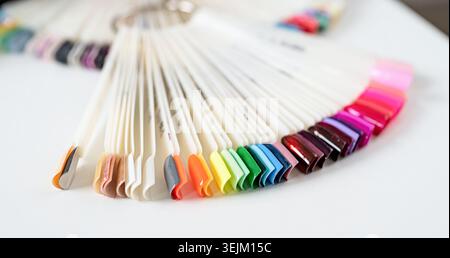 Bunte Kunststoff-Nagelspitzen auf dem Tisch im Manikürsalon Stockfoto