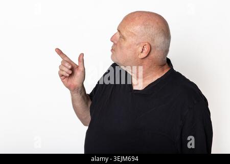 Seitenansicht eines älteren Mannes, der nach links zeigt, isoliert auf weißem Hintergrund Stockfoto