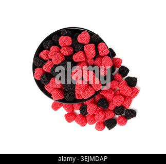Gummibeeren in der Schüssel isoliert, Kaubeeren, Gelee Brombeeren, rote Gelatinesbonbons und schwarze Fruchtmarmelade bedeckt mit kleinem knusprigem Zucker Stockfoto