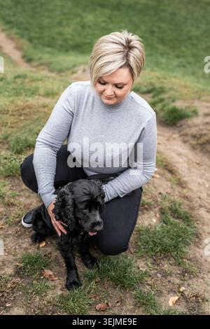 Black Cocker Spaniel mit seinem Besitzer im Park Stockfoto