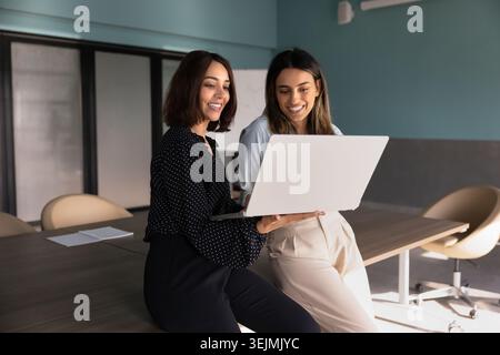 Zwei verschiedene Kolleginnen arbeiten im Büro an Laptops Stockfoto