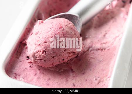 Hausgemachtes Beereneis in Metallwanne mit Schaufel. Nahaufnahme. Stockfoto