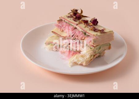 Trendige pinkfarbene Schokolade mit luftiger Füllung auf Marmorbrett. Leckeres Dessert. Stockfoto