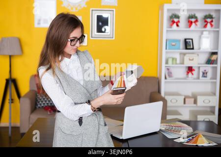 Die junge kreative Designerin spricht am Telefon und arbeitet im Büro Stockfoto