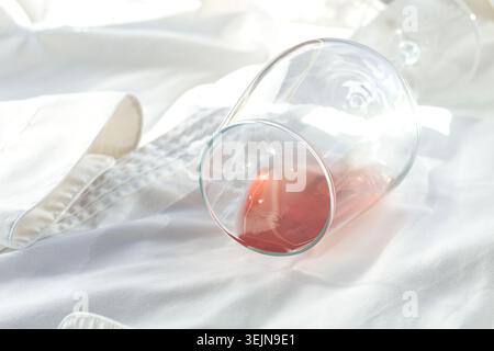 Glas, mit rosafarbenem Wein, verschüttet auf einem weißen Hemd, Nahaufnahme, selektiver Fokus, keine Leute, Konzept, Draufsicht, Stockfoto