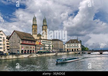 Grossmunster romanische Kirche und historische Altstadthäuser an der Limmat in Zürich, Schweiz. Bewölkter Junihimmel in Summe Stockfoto