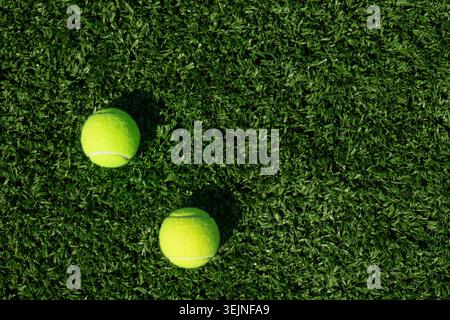 Zwei gelbe Tennisbälle auf grünem Sportplatz und Kunstrasen. Stockfoto