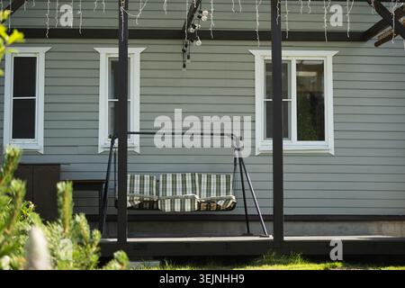 Haus mit Terrasse und grünem Gras davor. Sommer. Im Freien. Hinterhof. Stockfoto