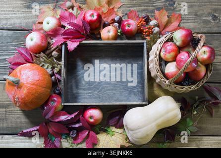 Stillleben im Herbst. Frisches Herbstobst, reife Äpfel, Kürbis und Holztablett auf dem Tisch. Kopierbereich. Stockfoto