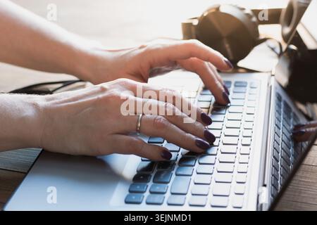 Nahaufnahme von Frauenhänden, die im Büro mit einem Laptop arbeiten. Stockfoto