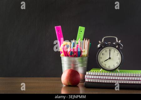 Back-to-School-Konzept. Schulbedarf, Wecker und Apfel. Stockfoto