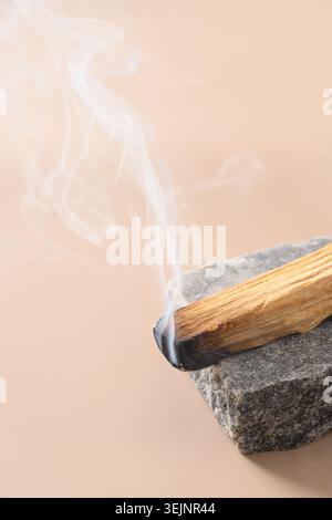 Palo Santo Räucherstäbchen, die auf Stein brennen. Stockfoto