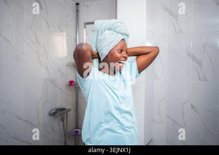 Glückliche junge erwachsene Frau, die sich die Selbstpflege-Morgenroutine genießt Stockfoto