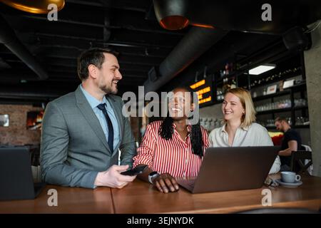 Verschiedene Geschäftsleute diskutieren während eines informellen Treffens im Café Stockfoto