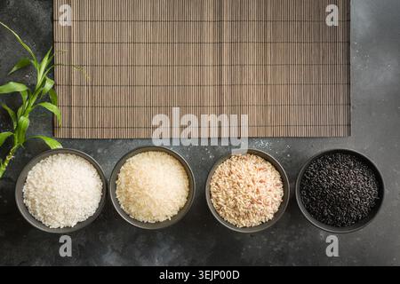 Verschiedene Sorten von Reis in Schalen. Ansicht von oben. Schwarzen Hintergrund. Platz für Text. Stockfoto