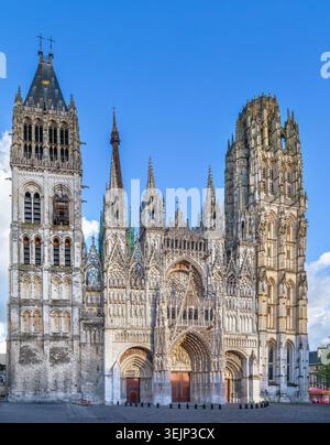 Kathedrale von Rouen, Frankreich, flacher Blick auf die Hauptfassade. Hohe gotische Steinarchitektur und Portale unter teilweise bewölktem Himmel Stockfoto