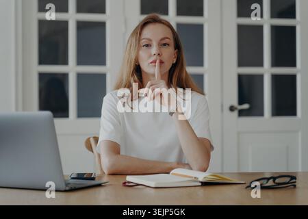 Lady Gesten schweigen im Konzept von Geheimnis und Privatsphäre. Die junge Geschäftsfrau arbeitet von zu Hause aus. Stockfoto