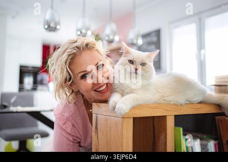 Frau lächelt mit Hauskatze Stockfoto